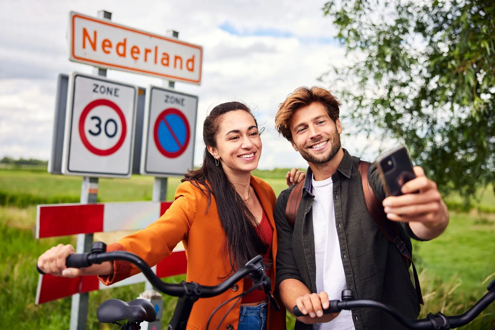 Twee gebruikers van de deelfiets tijdens een pauze op de fiets, die een selfie nemen.